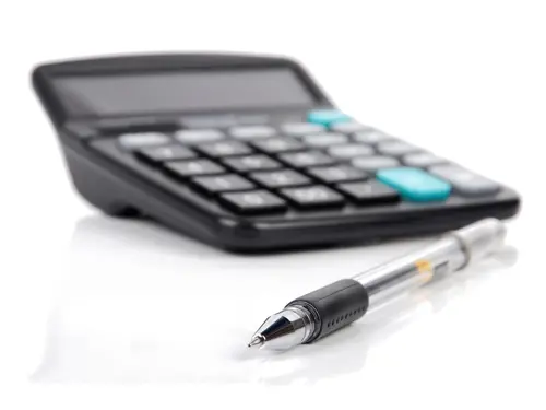 Nærbilde av en kalkulator og en pen