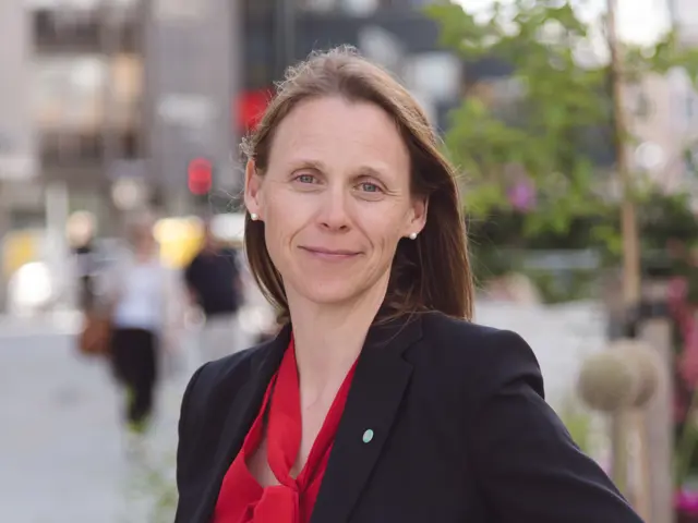 Lise Lyngsnes Randeberg, President i Tekna ser inn i kamera med en dus bakgrunn