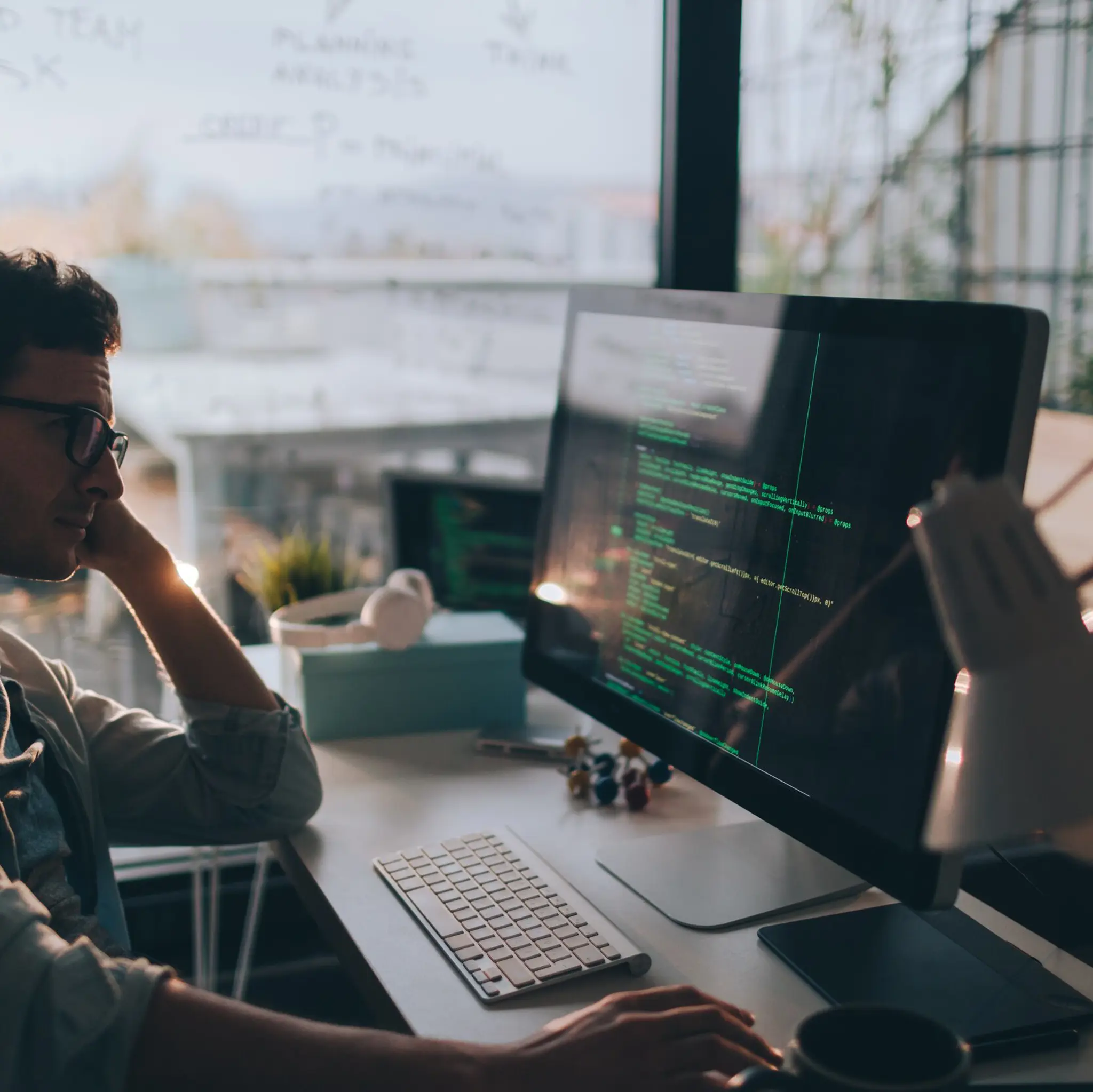 Mann som sitter foran skjerm med koder