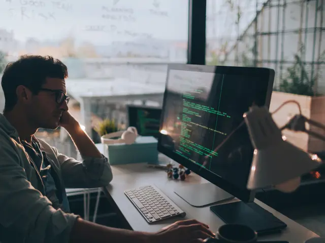 Mann som sitter foran skjerm med koder