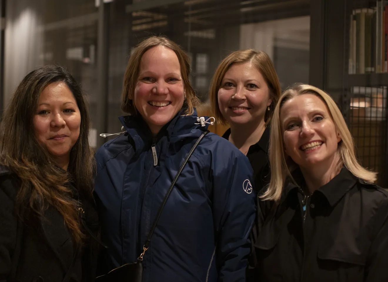 Gruppebilde av fire kvinner som smiler til kamera