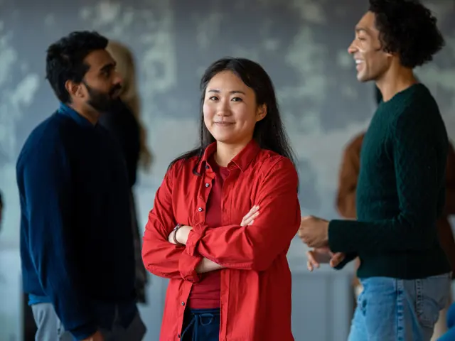 Ung kvinne med lurt smil og armene i kors