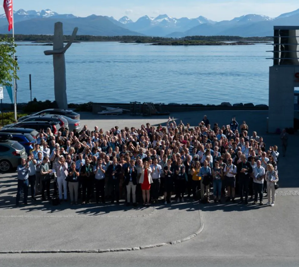 Gruppefoto av alle delegater på R-møtet i Molde i 2019. Bildet er tatt ovenfra og ned med bilde av fjorden og fjellene i bakgrunnen. 