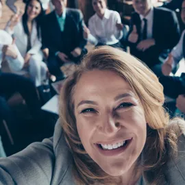 Leder som tar selfie med ansatte i bakgrunn