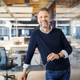 Mann, erfaren i arbeidslivet står i et kontorlandskap