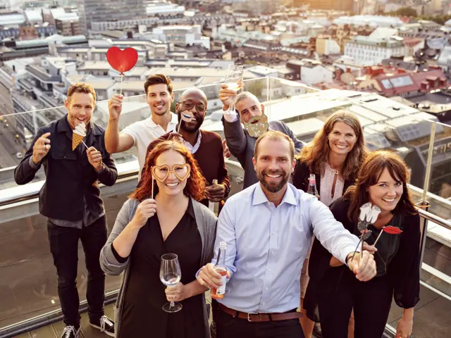 Gruppebilde av mennesker som feirer på en takterrasse