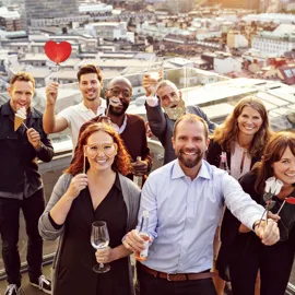 Gruppebilde av mennesker som feirer på en takterrasse