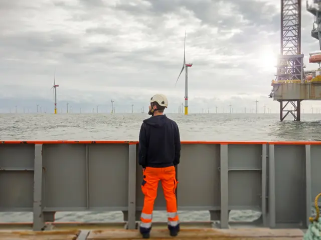 Arbeider på skip ser på offshore vindmøllepark