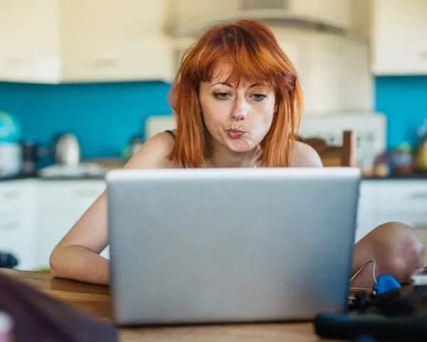 Ung kvinne leser e-post og er skeptisk