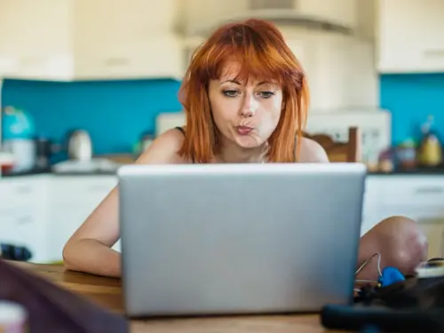 Ung kvinne leser e-post og er skeptisk
