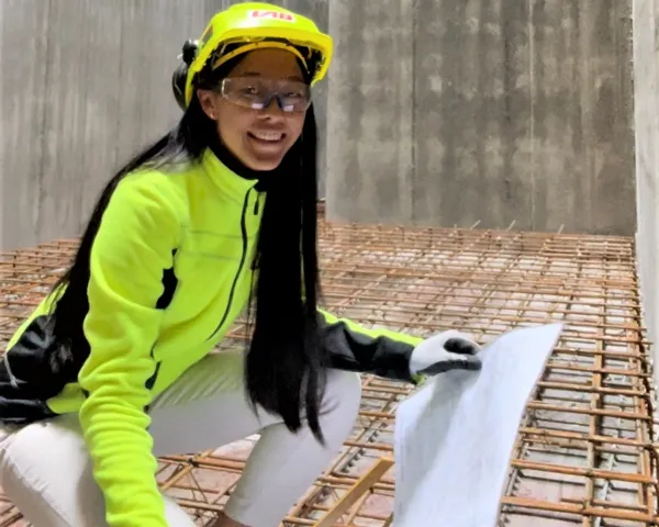 Alexandra Thorsen i verneutstyr med plantegning i hånden i betongrom