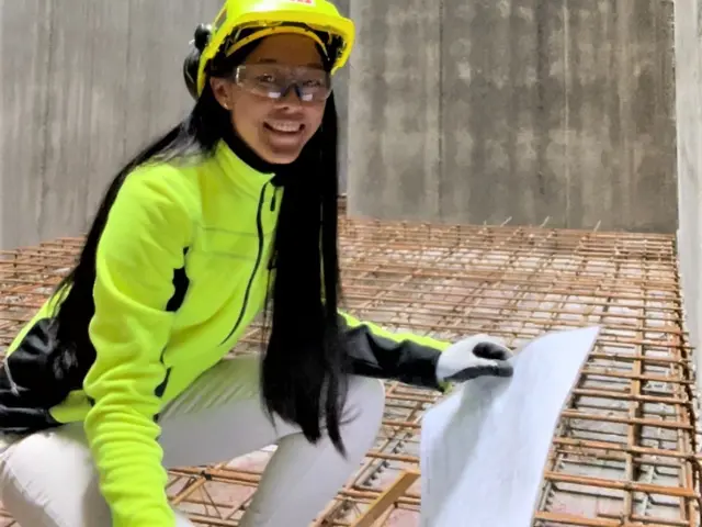 Alexandra Thorsen i verneutstyr med plantegning i hånden i betongrom