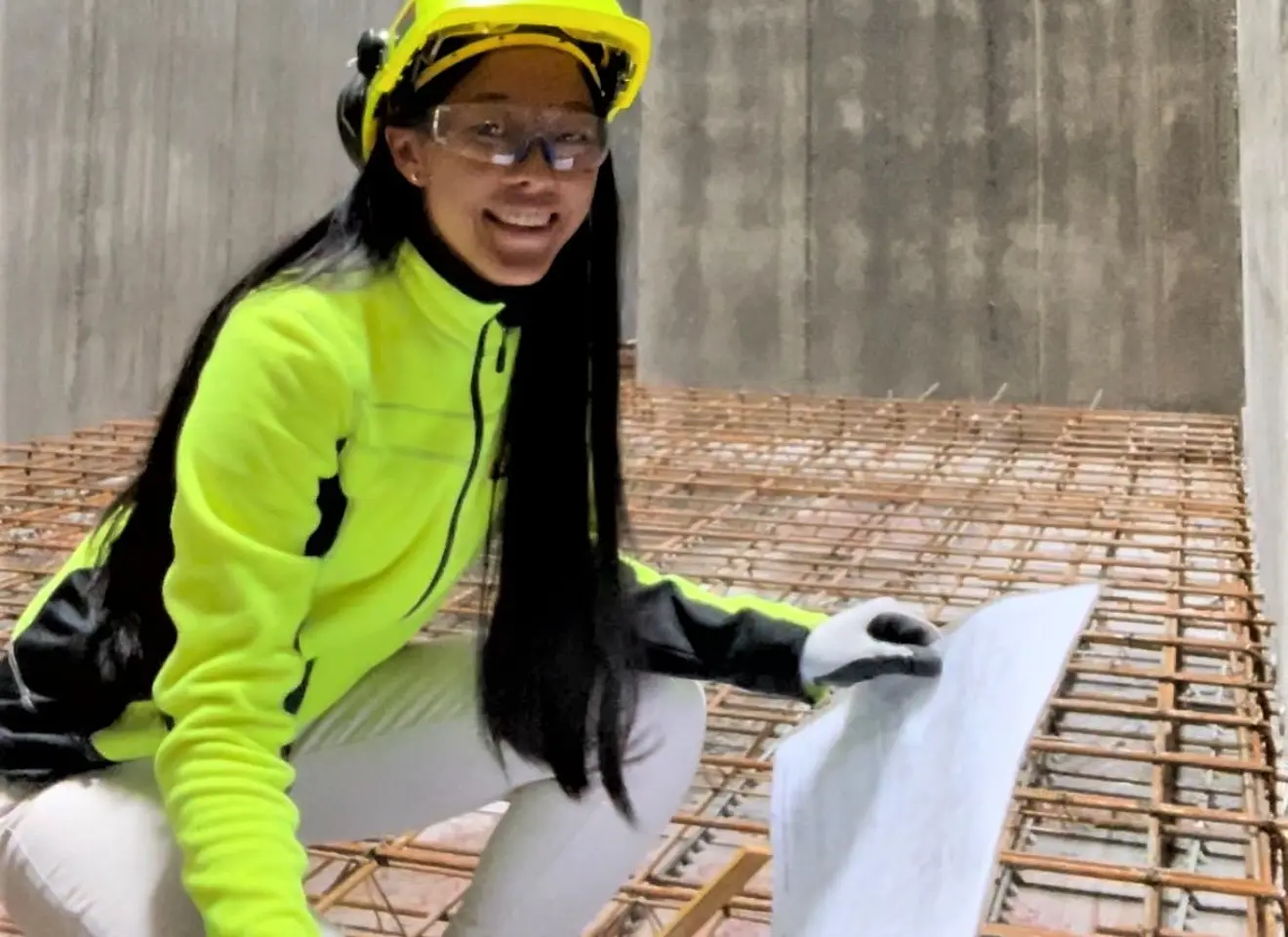 Alexandra Thorsen i verneutstyr med plantegning i hånden i betongrom