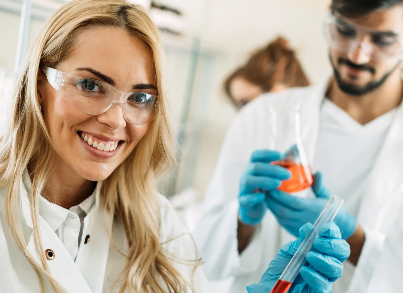 Illustrasjonsbilde av en ung kvinne og flere unge menn med verneutstyr i labor