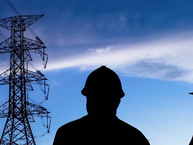 Mørk silhuett av to personer med vernehjelm mot kveldshimmel med høyspentledning