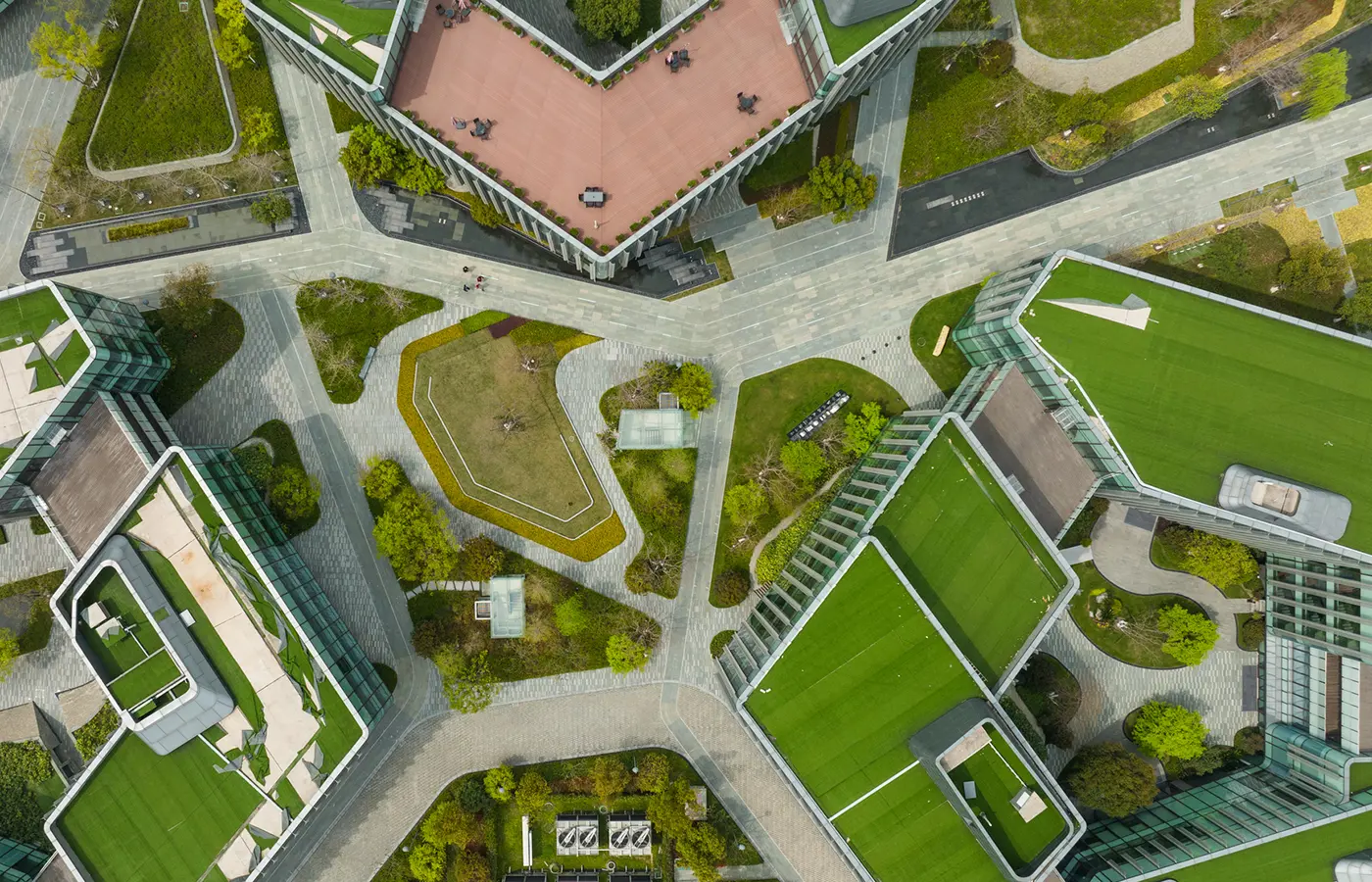 Dronebilde av moderne byutvikling med grøntområder og urban infrastruktur