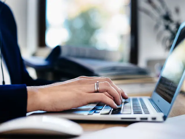 Person arbeider på bærbar PC i moderne arbeidsmiljø med fokus på digital produktivitet.