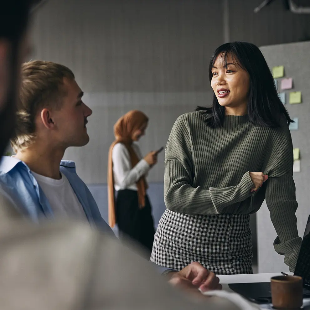 Unge kolleger diskuterer ideer i et moderne kontormiljø.