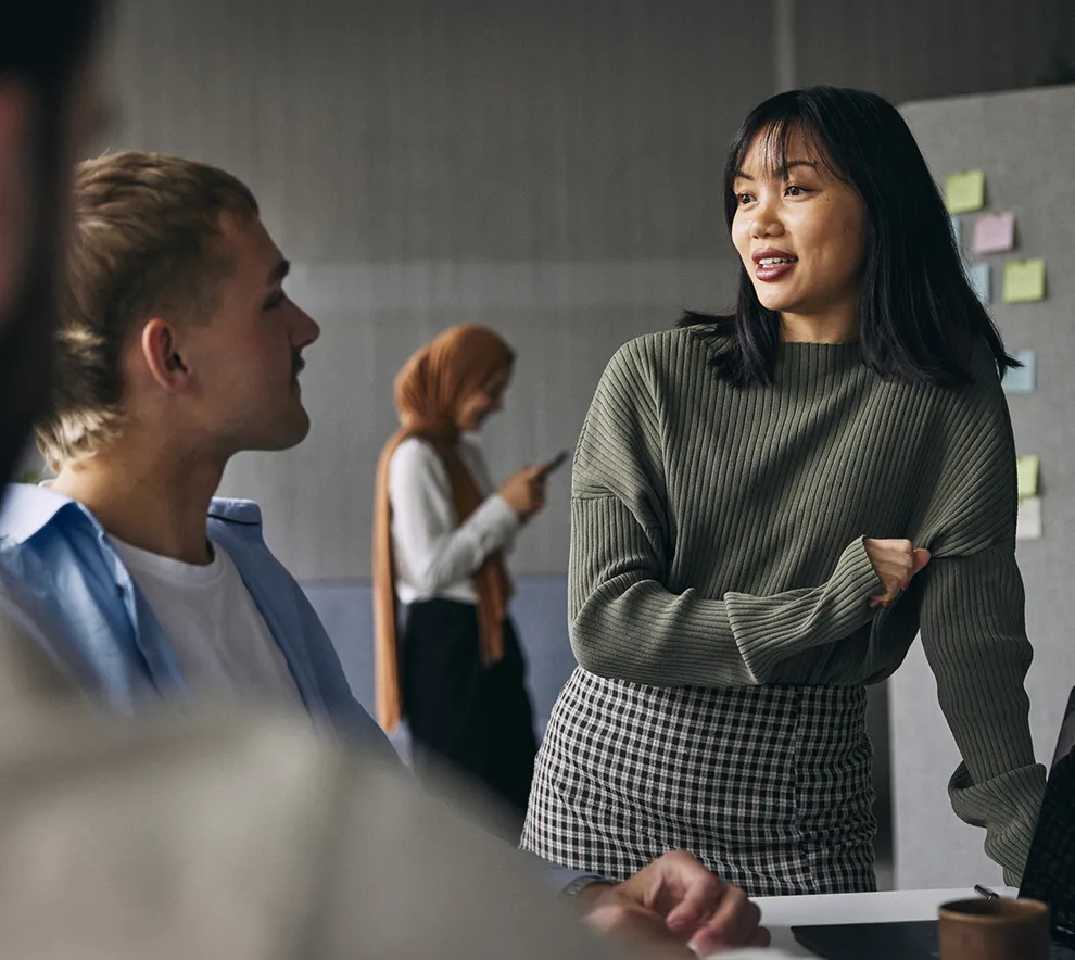 Unge kolleger diskuterer ideer i et moderne kontormiljø.