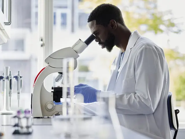Forsker undersøker biologiske prøver i mikroskop på laboratorium.