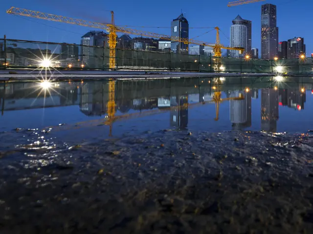 Byggeplass i by med kraner og vannspeil som viser utfordringer med overvann.