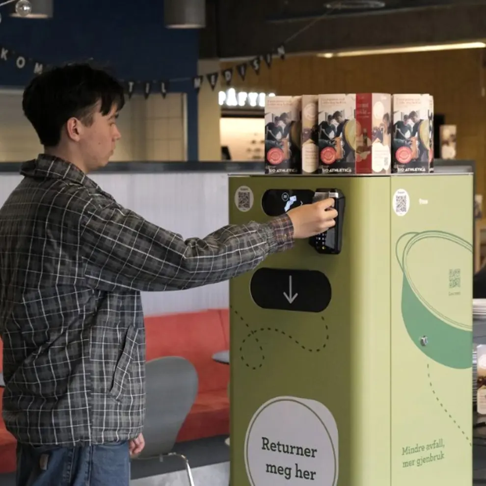 Person bruker smart returstasjon for gjenbruksemballasje og sirkulærøkonomi.