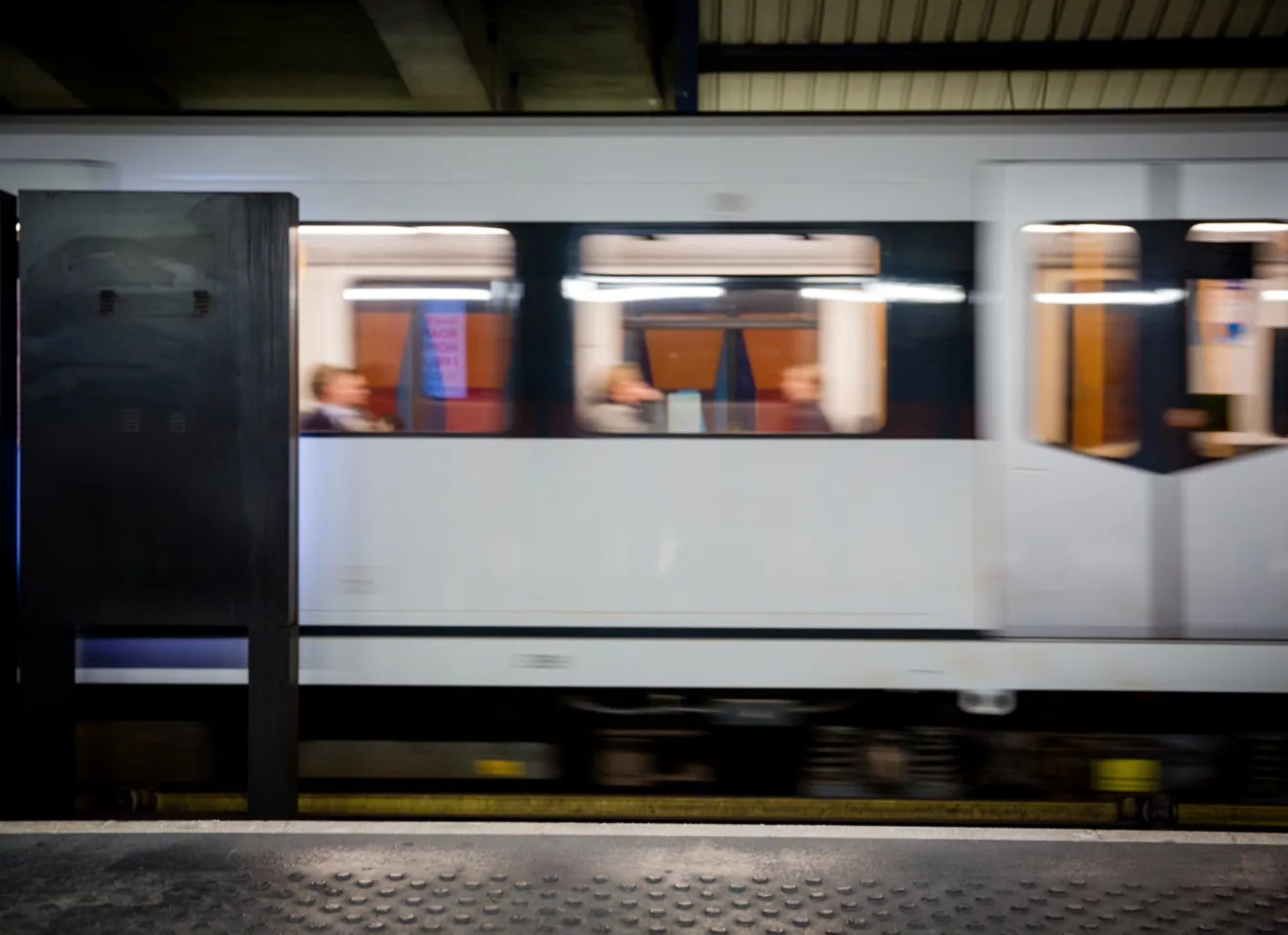 T-bane i bevegelse ved stasjon i Oslo med passasjerer om bord, illustrerer kollektivtransport og urban mobilitet.