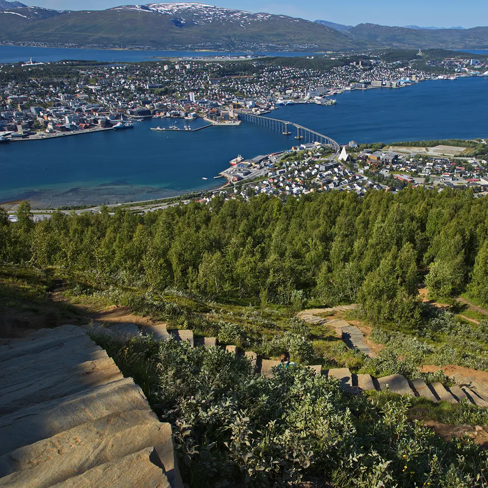 Panoramautsikt over Tromsø med Sherpatrappa, fjord, bro og fjell i sommerlandskap.