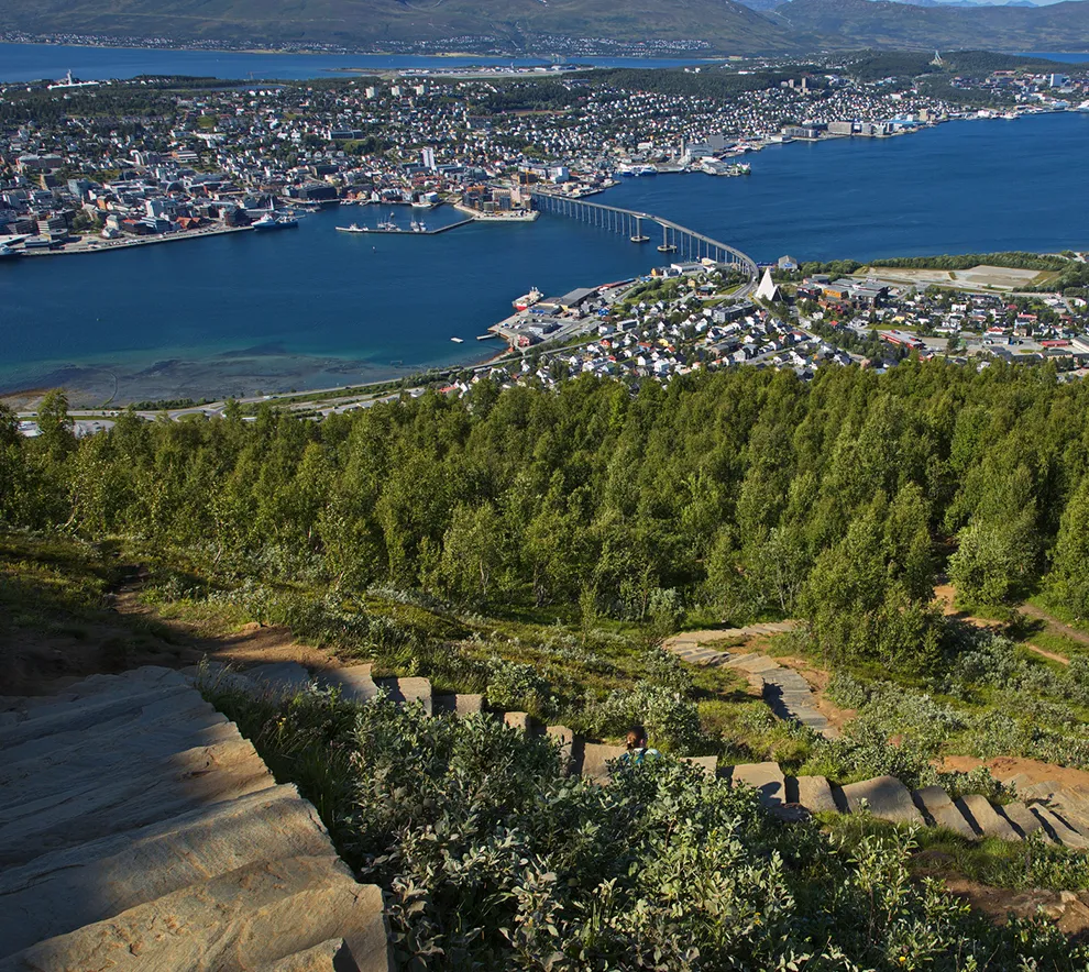 Panoramautsikt over Tromsø med Sherpatrappa, fjord, bro og fjell i sommerlandskap.