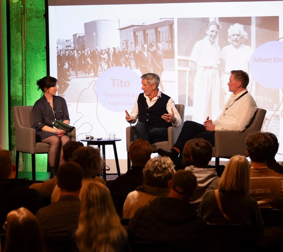 Paneldebatt under klimafestival med foredragsholdere på scene og publikum i salen.