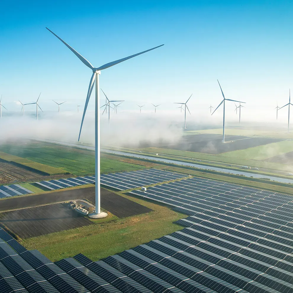 Vindmøller og solcellepaneler i landskap – fornybar energi og bærekraft.