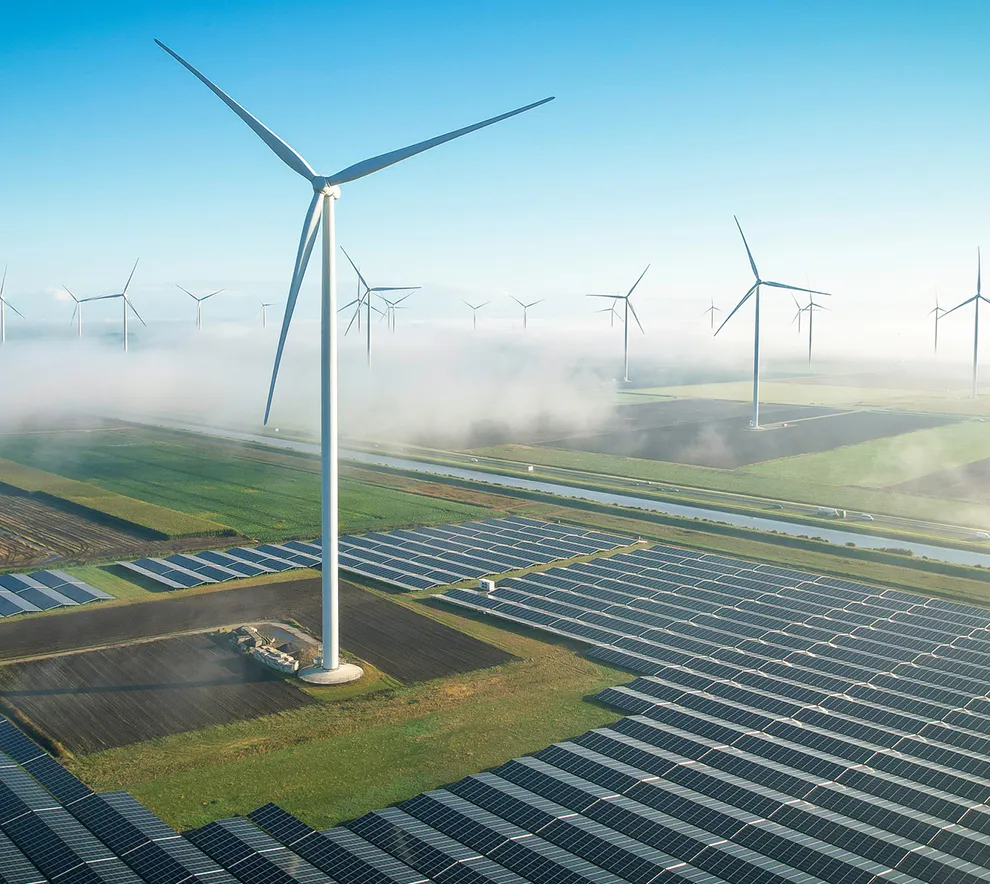 Vindmøller og solcellepaneler i landskap – fornybar energi og bærekraft.