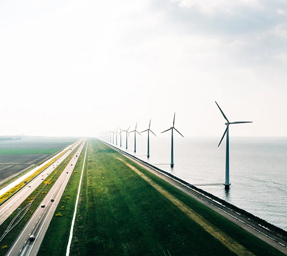 En serie vindmøller langs en kystlinje.