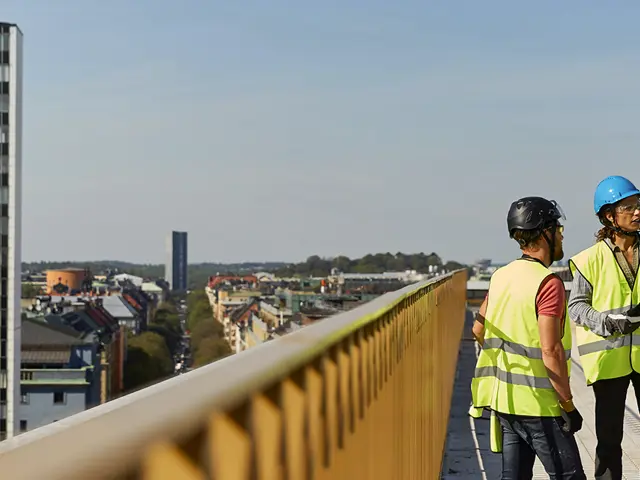 Byggeplassarbeidere i verneutstyr på taket av et stort bygg