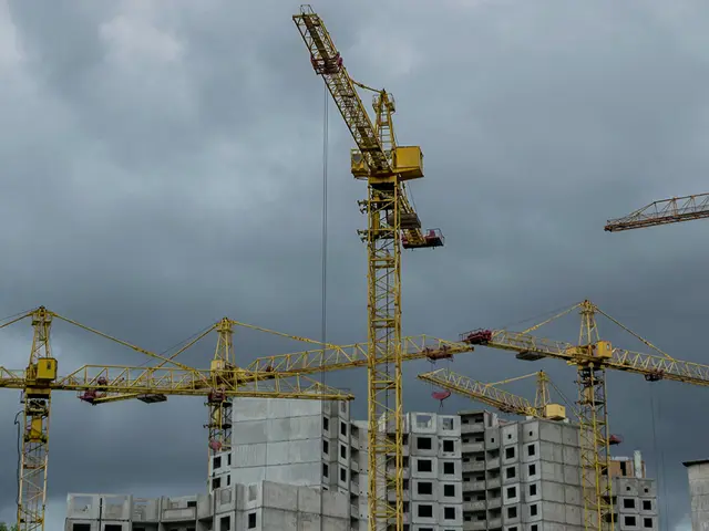 Byggeplass med heisekraner og dramatiske skyer