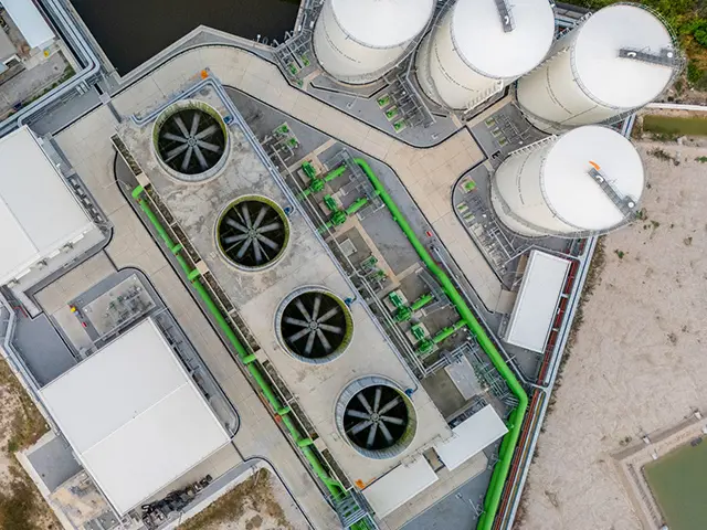 Luftfoto av et karbonfangstanlegg med kjøletårn, lagringstanker og rørledninger.