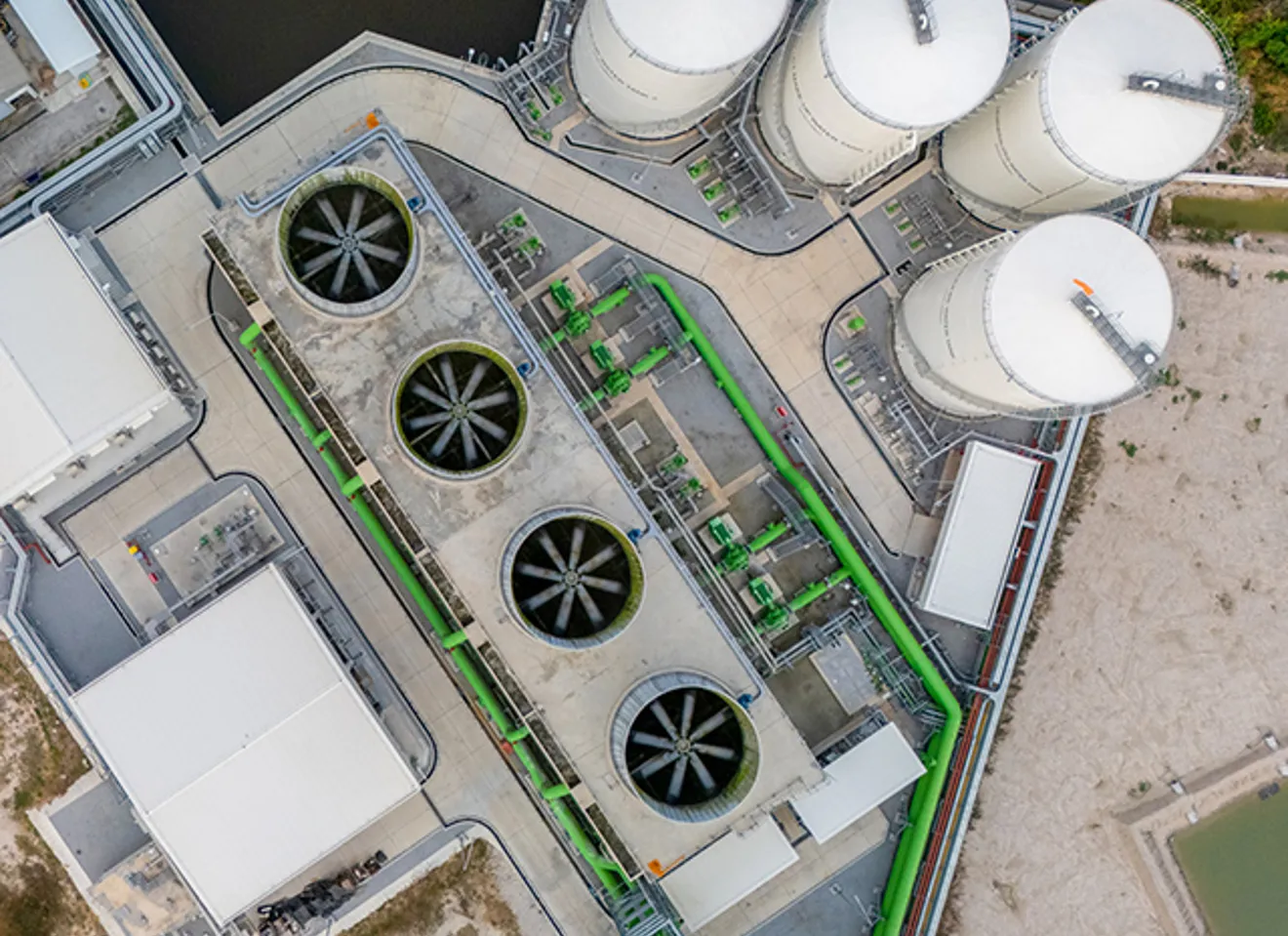 Luftfoto av et karbonfangstanlegg med kjøletårn, lagringstanker og rørledninger.