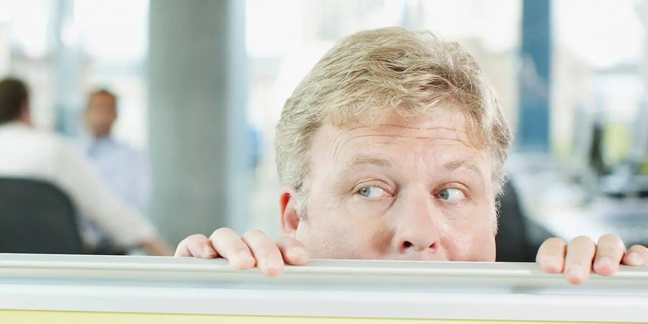 mann gjemmer seg nesten under bordet