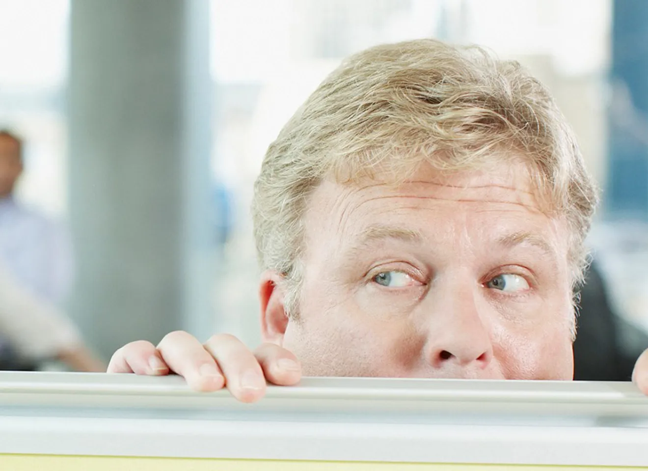 mann gjemmer seg nesten under bordet