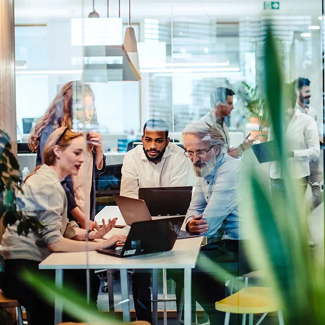 Blandet team i kreativ workshop som deler idéer og samarbeider på tvers.