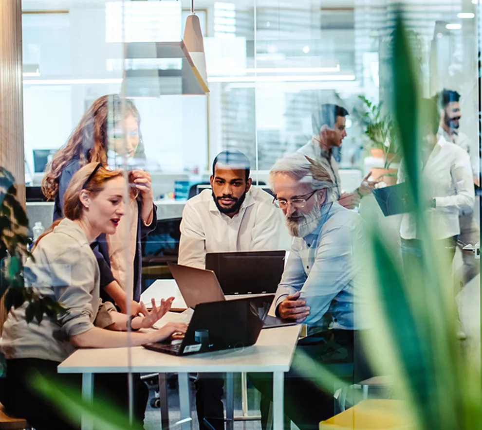 Blandet team i kreativ workshop som deler idéer og samarbeider på tvers.