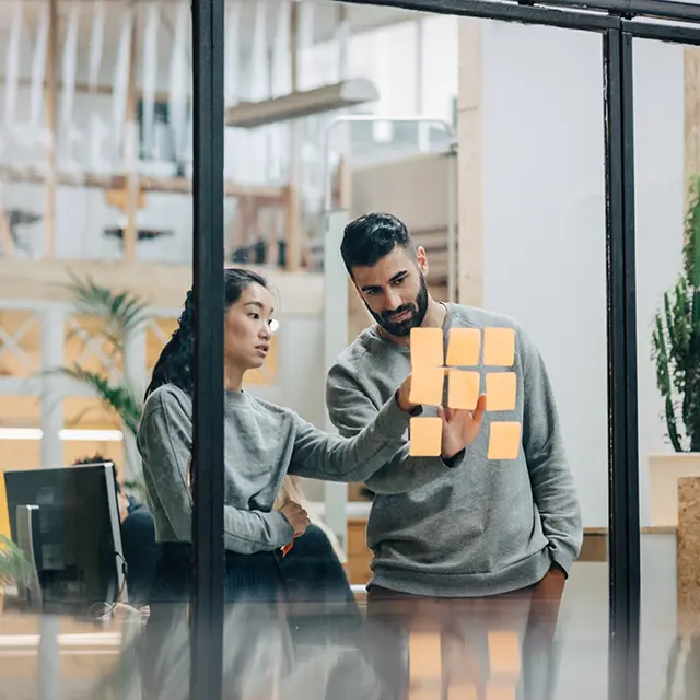 To personer jobber med strategi i et kontorlandskap.