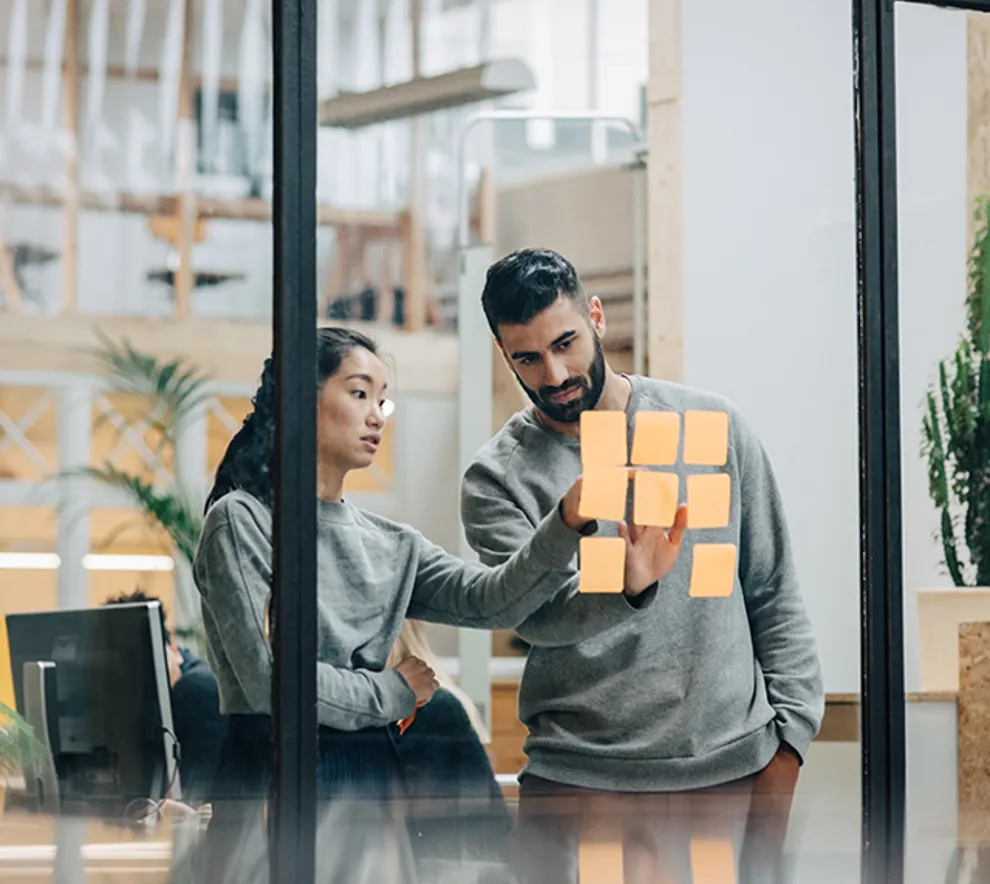 To personer jobber med strategi i et kontorlandskap.
