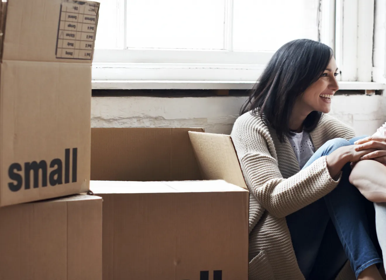 Kvinne som sitter ved flytteesker