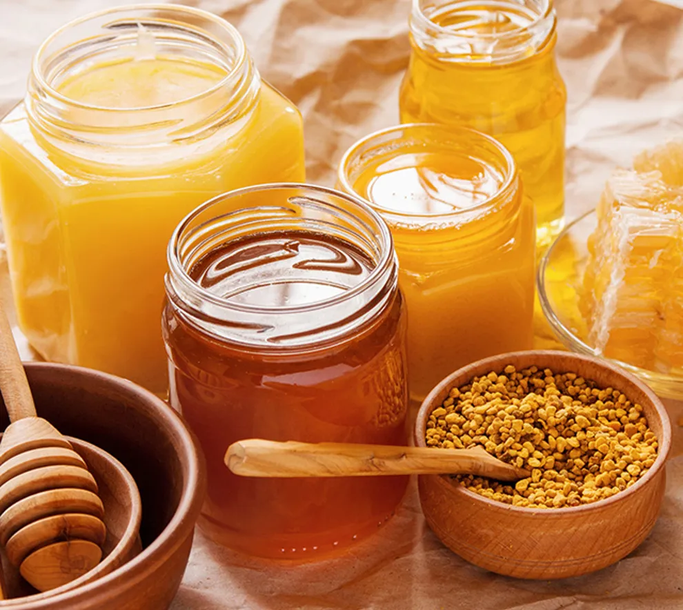 Flere typer honning i glass med varierende gyldne farger.