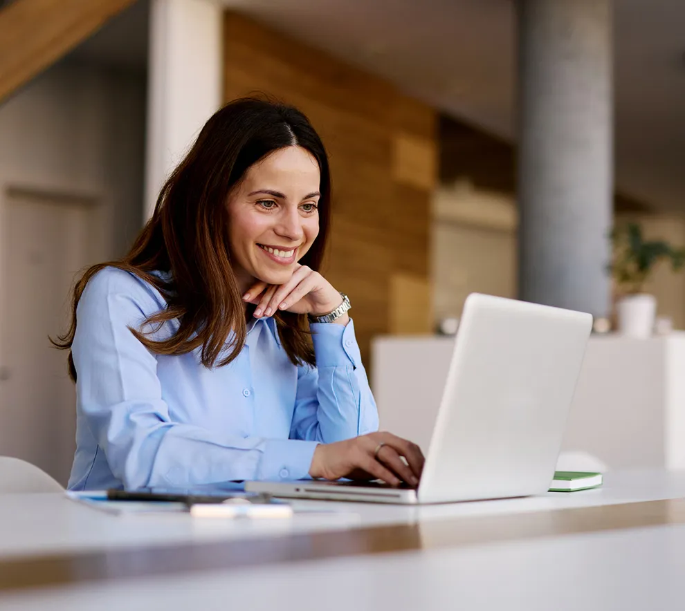 Person jobber konsentrert på PC i moderne kontormiljø