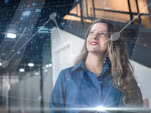 Kvinne med langt hår smiler ser opp på  digitale binærkoder, grafer og lyseffekter er lagt over for å skape en futuristisk stemning