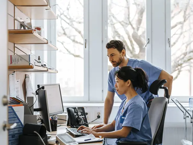 Lege og sykepleier jobber med digitale helsedata på datamaskin i sykehusmiljø