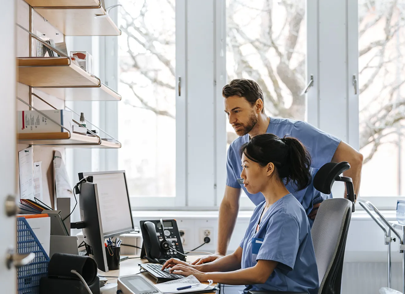 Lege og sykepleier jobber med digitale helsedata på datamaskin i sykehusmiljø