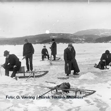 Historisk foto av isfiske i Oslofjorden med fiskere på isen vinterstid.
